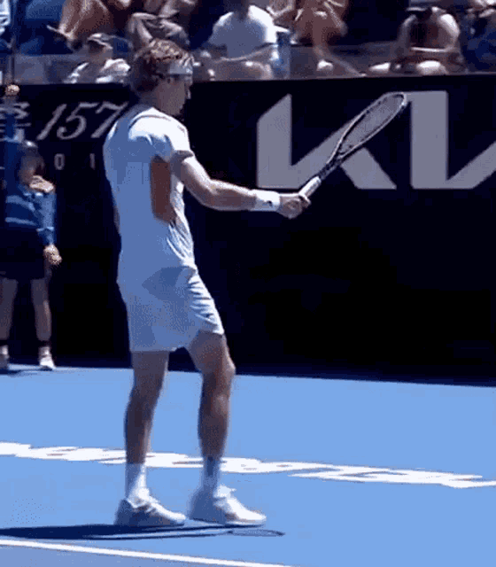 a man is holding a tennis racquet on a blue court .
