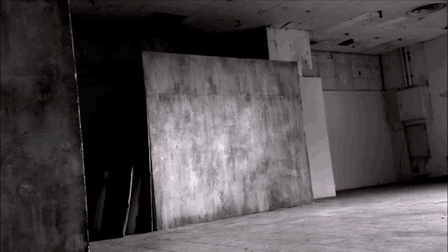 a black and white photo of an empty room with a wall that says n on it