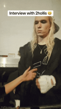 a man with long blonde hair is being interviewed by a woman with a bandaged hand