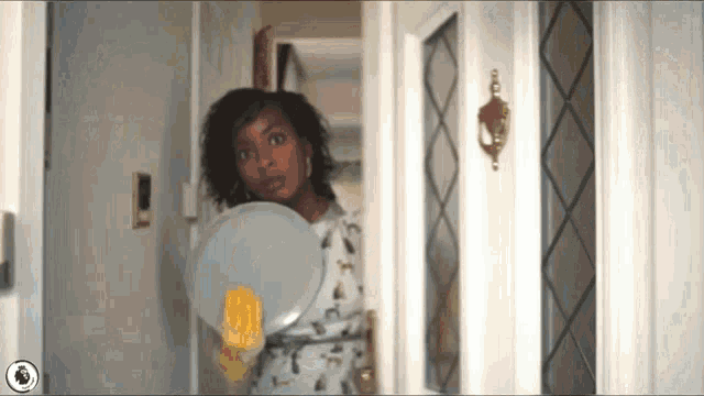 a woman wearing yellow gloves is holding a white plate in her hand .