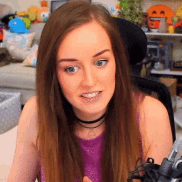 a woman in a purple tank top with a choker around her neck