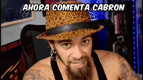 a man with a beard wearing a leopard print hat with the words ahora comenta cabron above him