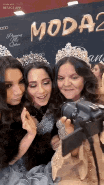 a group of women are posing for a picture in front of a sign that says moda