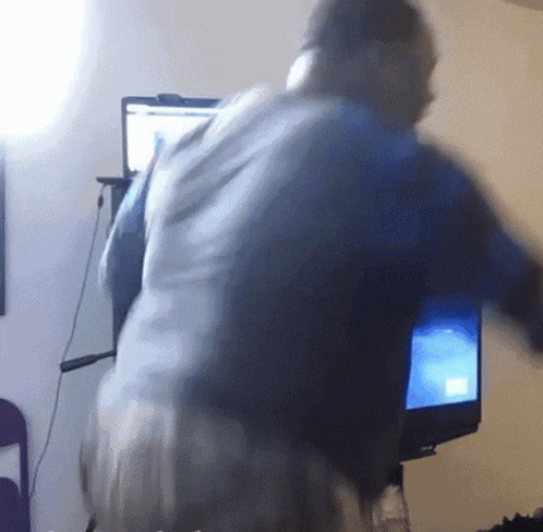 a blurry picture of a person standing in front of a computer monitor