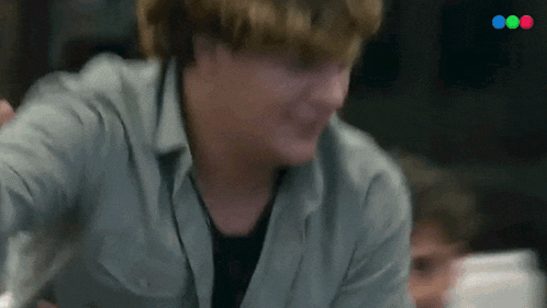 a blurry picture of a man in a grey shirt with a red and blue circle in the corner