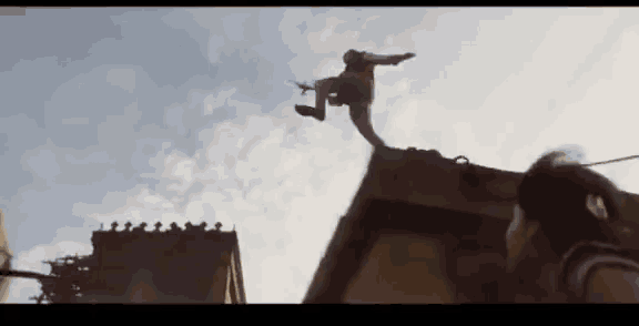 a man is jumping off a building while a woman watches