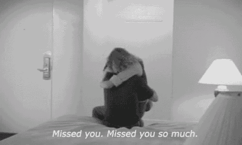 a black and white photo of a woman hugging a man on a bed with the words missed you missed you so much