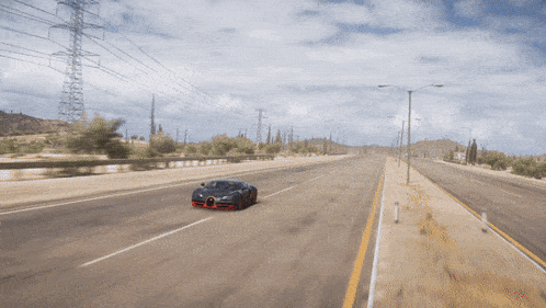 a black bugatti is driving down a desert road