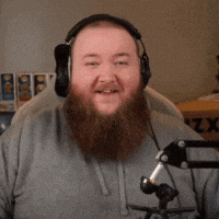 a man with a beard is wearing headphones and smiling .