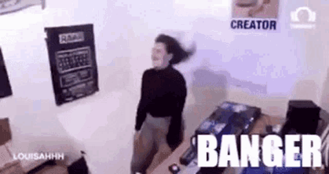 a woman is dancing in a room with the words banger written on the wall behind her .