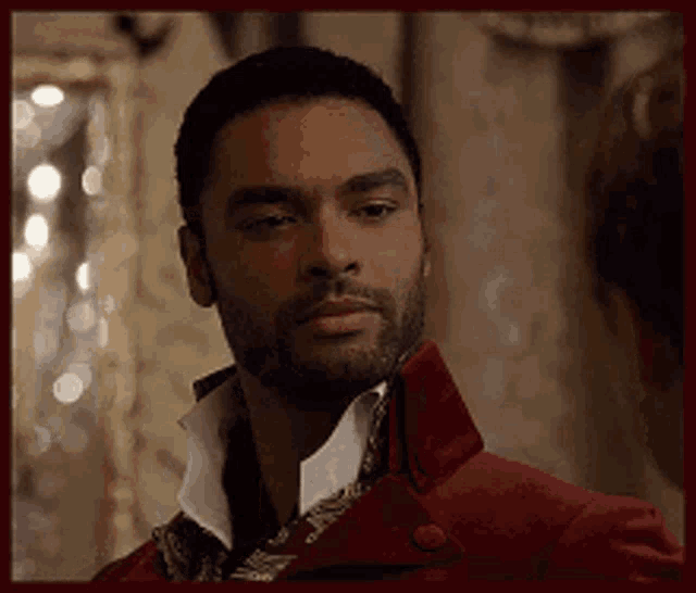 a man with a beard is wearing a red jacket and a scarf .