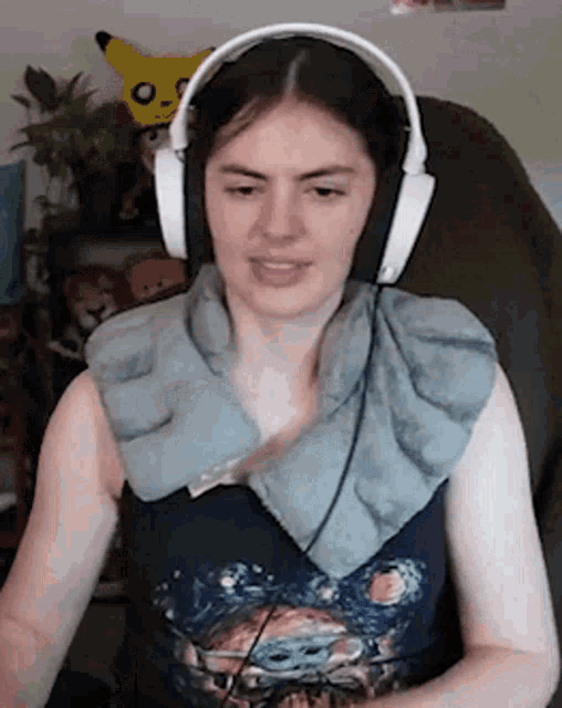 a woman wearing headphones and a towel around her neck is sitting in a chair .
