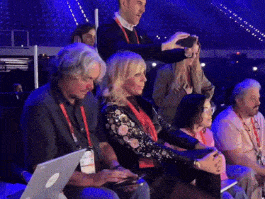 a man is taking a picture of a woman in a crowd
