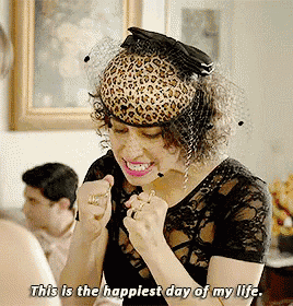 a woman wearing a leopard print hat is smiling and saying this is the happiest day of my life