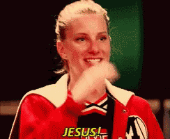 a woman wearing a red jacket with jesus written on it