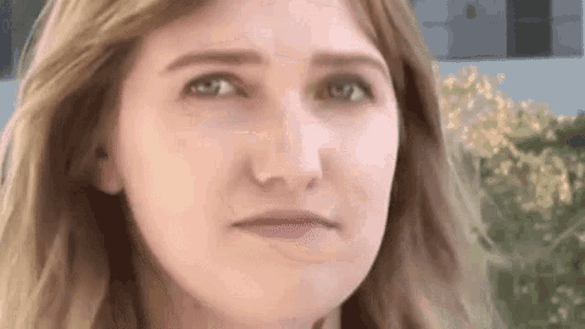 a close up of a woman 's face with a slight smile on her face .