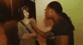 a woman is standing in front of a painting of a woman and talking to it .