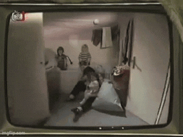 a group of people are sitting in a room on a tv screen