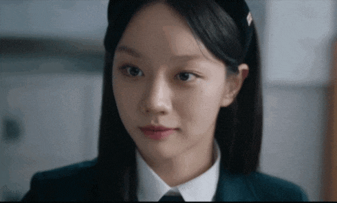 a close up of a young woman wearing a school uniform and a headband .