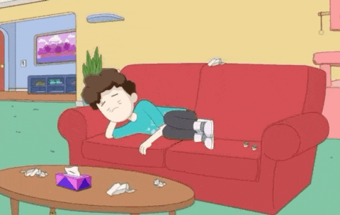 a cartoon of a man laying on a red couch with a box of tissues on the table .
