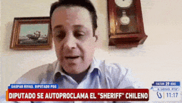 a man is sitting in front of a wall clock and a sign that says " diputado se autoproclama el sheriff "