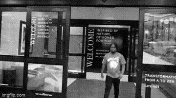 a man is standing in front of a welcome sign
