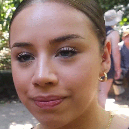 a close up of a woman 's face with earrings on