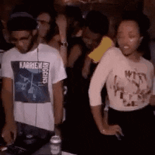a man and a woman are dancing in a club while a man is playing music .
