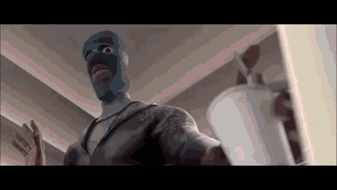 a cartoon character wearing a blue mask is holding a cup of soda .