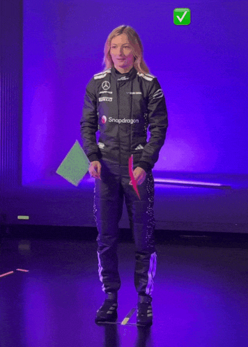 a woman in a snapdragon jacket is holding a green flag