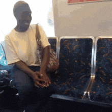 a man in a white shirt is sitting in a blue chair