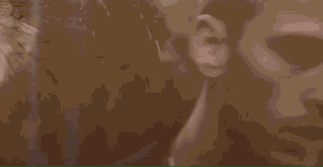 a man with a nose ring is looking at his reflection in a mirror