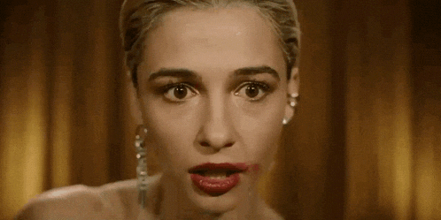 a woman with red lipstick on her lips is making a face .