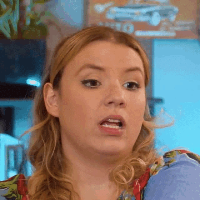 a woman is making a funny face in front of a sign that says ' ford '