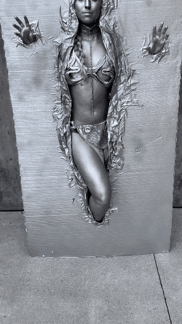 a statue of a woman in a bikini is being displayed