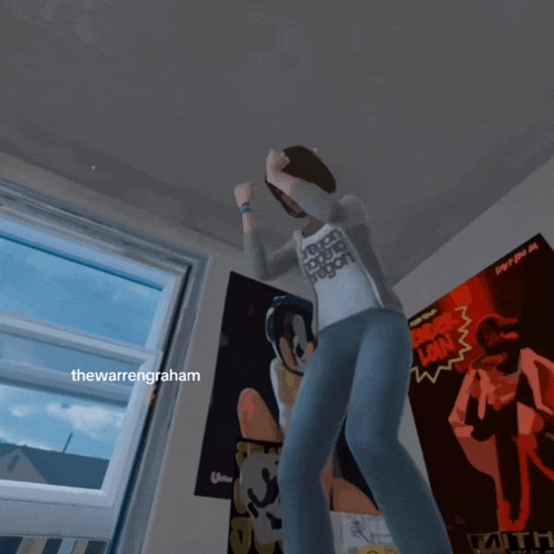a person is dancing in a room with posters on the wall and the word graham on the bottom right