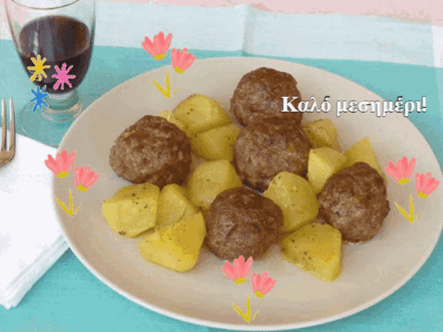 a plate of meatballs and potatoes with a glass of wine in the background and a greeting in a foreign language