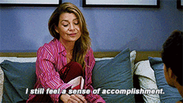 a woman is sitting on a couch talking to a man and saying " i still feel a sense of accomplishment "