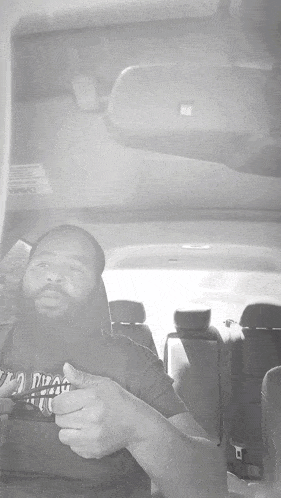a man sitting in a car with a shirt that says " i dig "