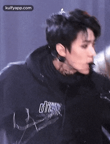 a close up of a person wearing headphones and a black hoodie .