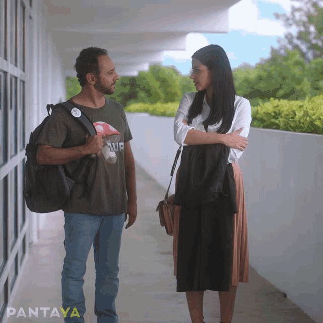 a man and a woman are walking down a hallway and the word pantaya is on the bottom right
