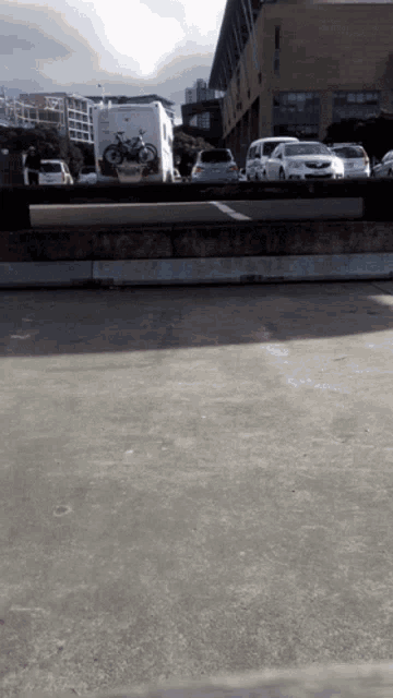 a white van with a bike on the back is parked in a parking lot