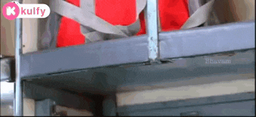 a red bag is hanging from a metal railing with a kulfy logo on the bottom right