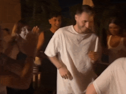 a man is dancing in a crowd of people at a party .