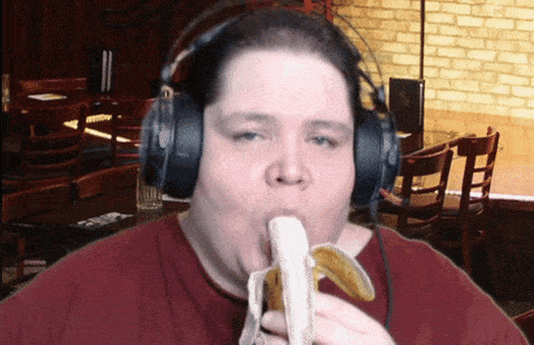 a man wearing headphones eats a banana in a restaurant