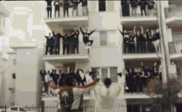a group of people are standing in front of a building .
