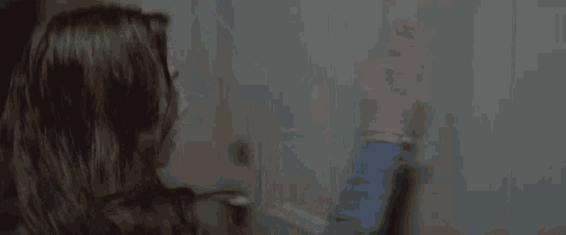 a woman is leaning against a wall with her hands on it .