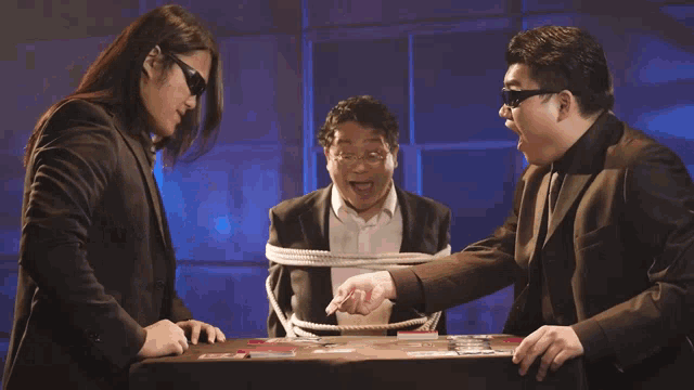 a man in a suit is tied up with a rope and playing a game