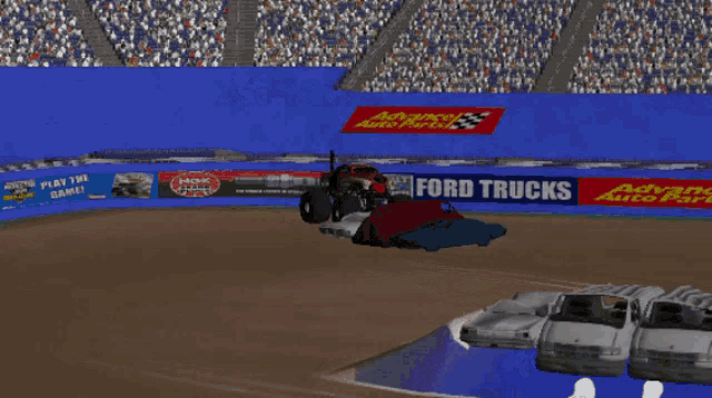 a monster truck is jumping over a row of toy cars in front of a sign that says jack in the box