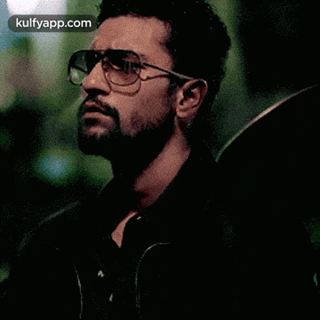 a man with a beard wearing sunglasses and a black jacket